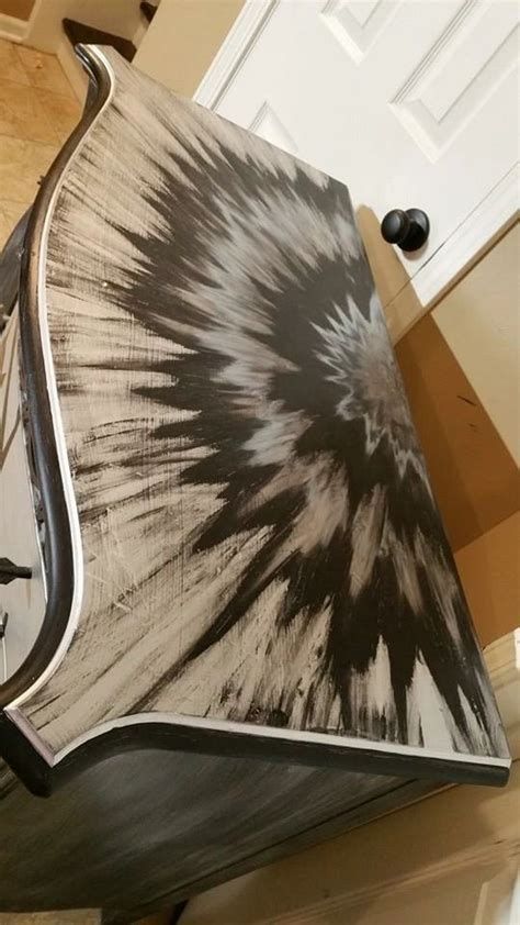 a black and white tie - dyed chair sitting on top of a hard wood floor