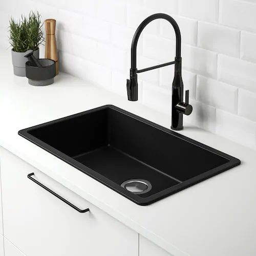 a black kitchen sink sitting under a faucet next to a white counter top