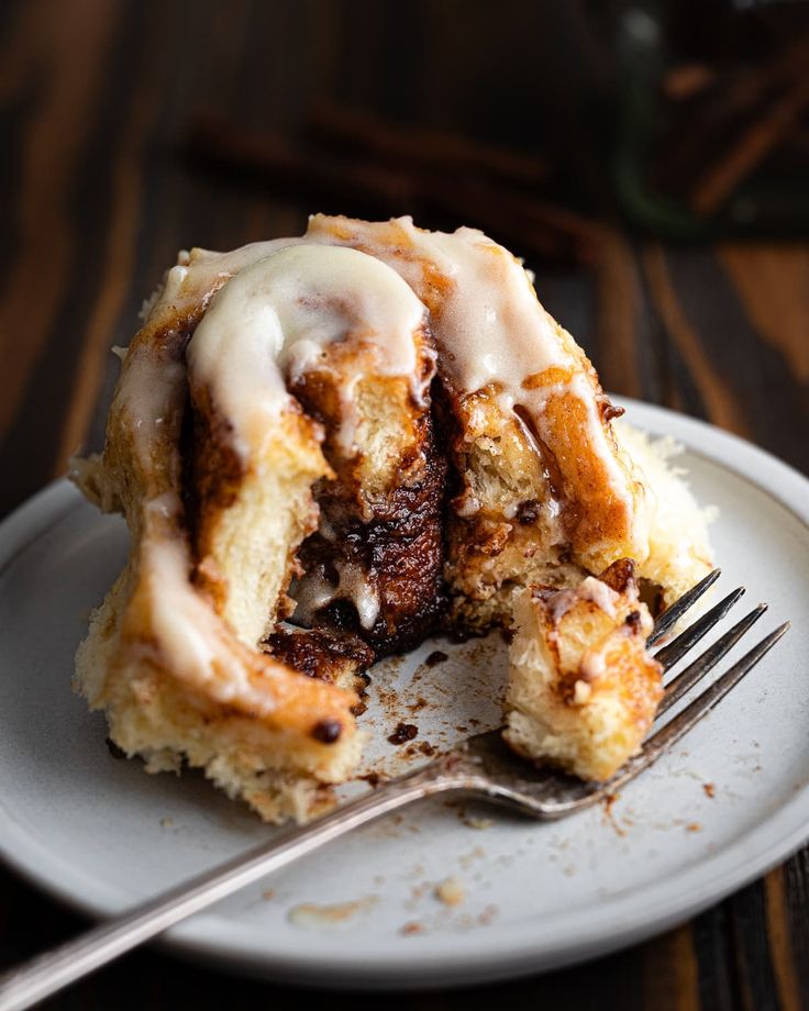 a cinnamon roll on a plate with a fork