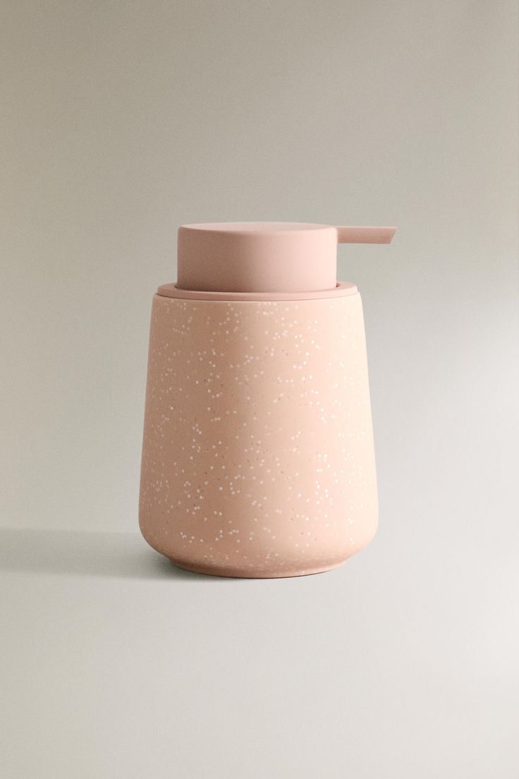 a pink vase sitting on top of a white table