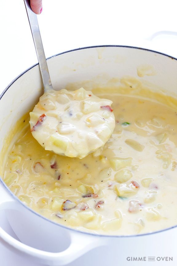 a person is spooning some food into a pot with potatoes and cream in it