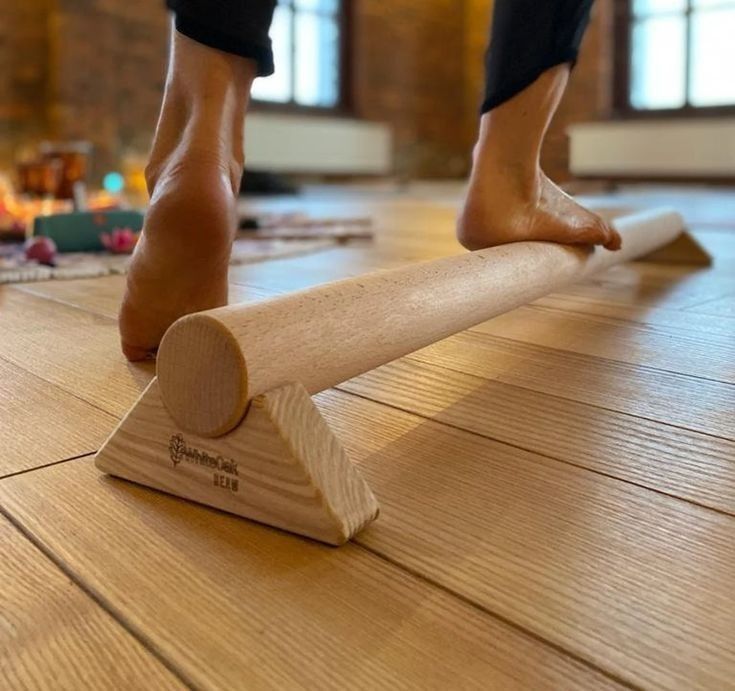 a person standing on top of a wooden floor next to a piece of wood that has been cut in half