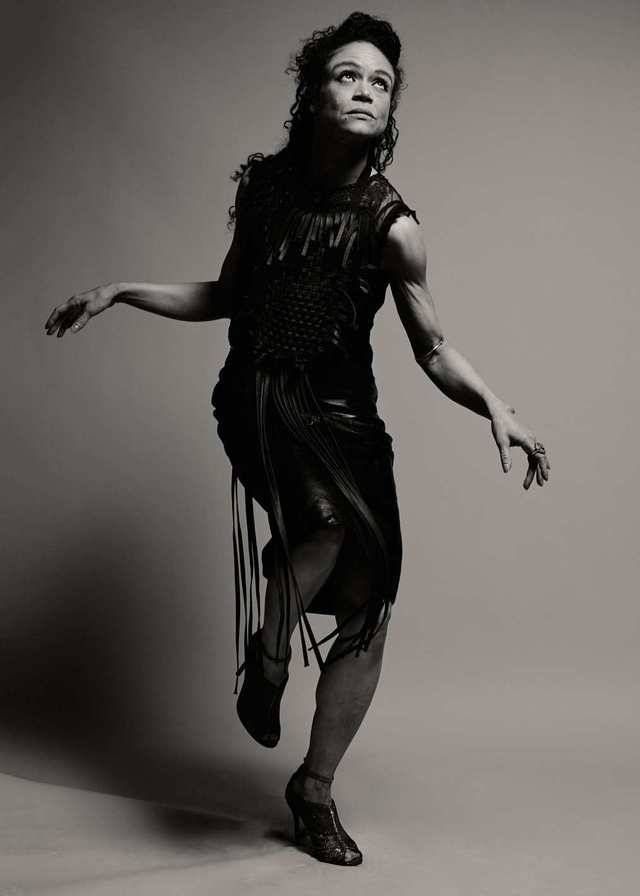 a black and white photo of a woman in a fringed dress with her arms outstretched