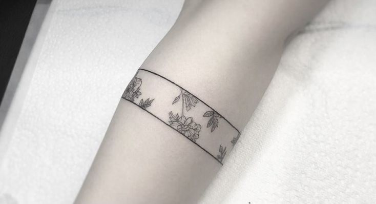 a woman's arm with a tattoo on it that is decorated with flowers and leaves