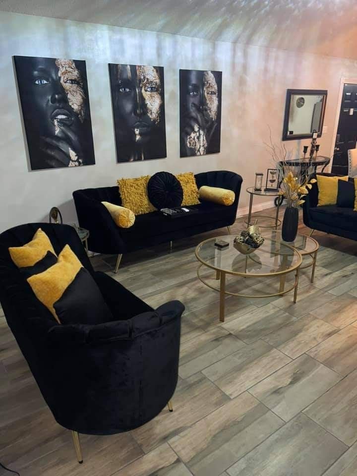 a living room filled with black couches and yellow pillows