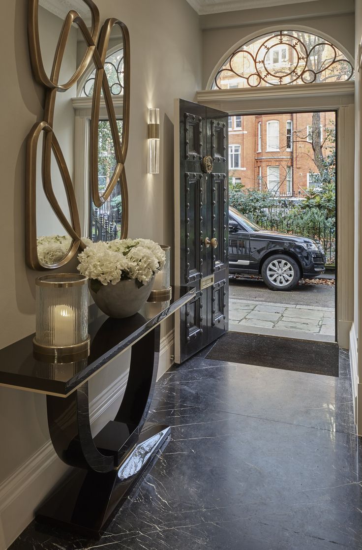 an entry way leading to a car parked in front of the door and into the house