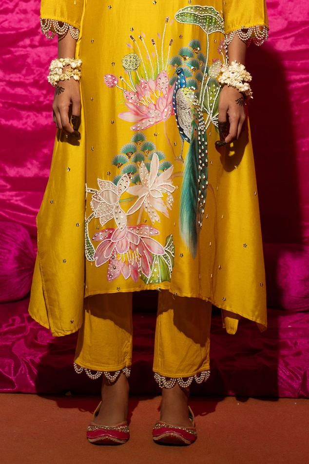 Yellow A-line kurta with floral placement print and sequin, pearl embroidery. Paired with pant and fringe lace bordered dupatta.
Components: 3
Pattern: Printed, Embroidery
Type Of Work: Floral, sequin, pearl
Neckline: Round
Sleeve Type: Long sleeves
Fabric: Chanderi Silk, Cotton, Lining: Shantoon
Color: Yellow
Other Details: 
Pearl embellished scallop border
Fringe tassel embellished bordered dupatta
Length:
Kurta: 45 inches
Pant: 38 inches
Occasion: Mehendi and Haldi - Aza Fashions Printed Embroidery, Scallop Border, Kurta Set For Women, Pearl Embroidery, Placement Print, A Line Kurta, Lace Border, Tassel Fringe, Kurta Set