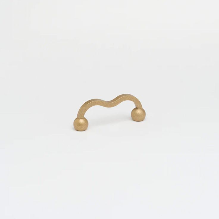 a gold ring with two balls on it