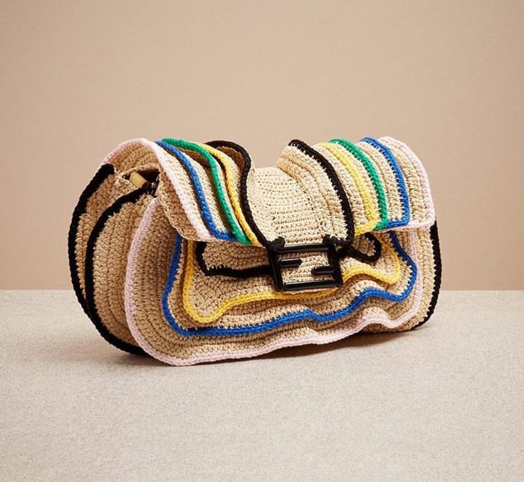 a crocheted purse sitting on top of a white table next to a brown wall