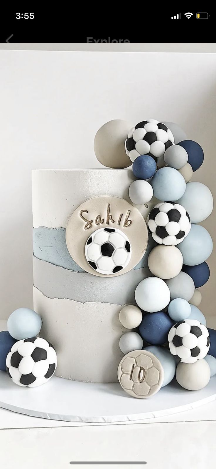 a soccer themed birthday cake with blue and white balls around it, including the number ten