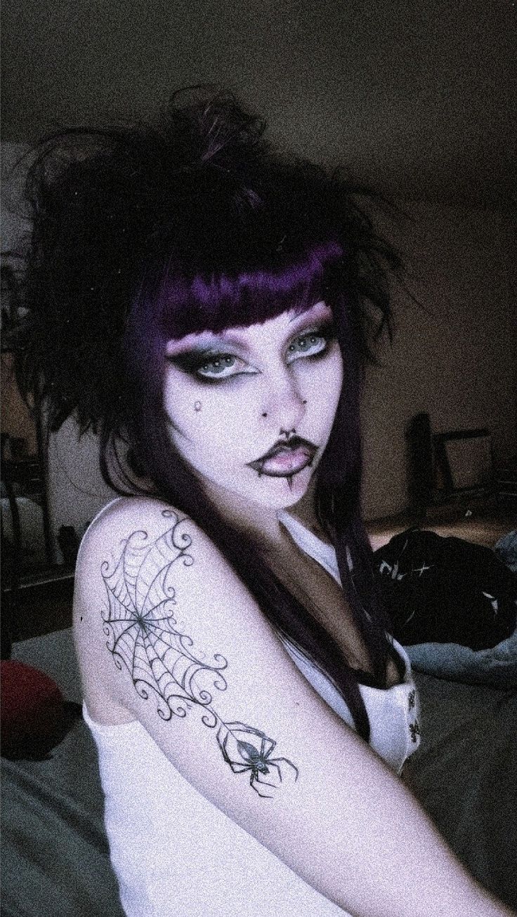 a woman with purple hair and tattoos on her arm