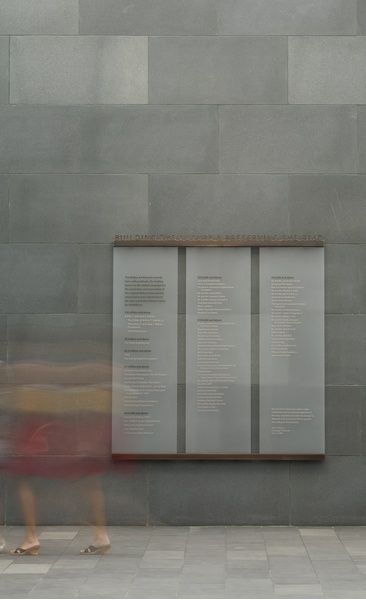 a woman walking past a wall with two panels on it