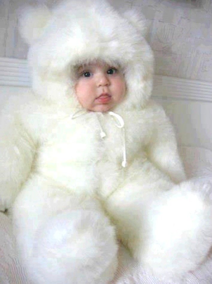 a baby is dressed in a white teddy bear costume