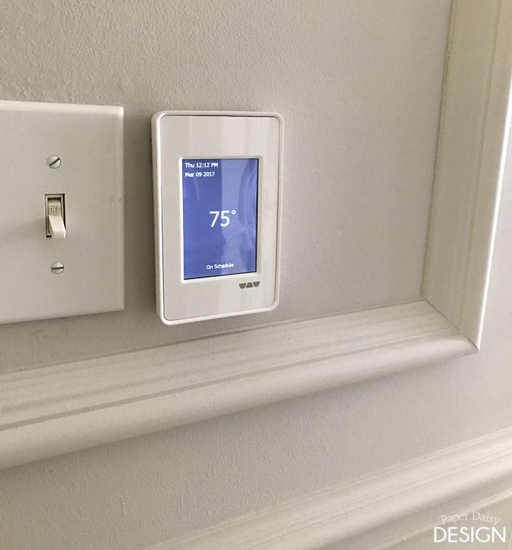 thermostaer is on the wall next to an electrical outlet