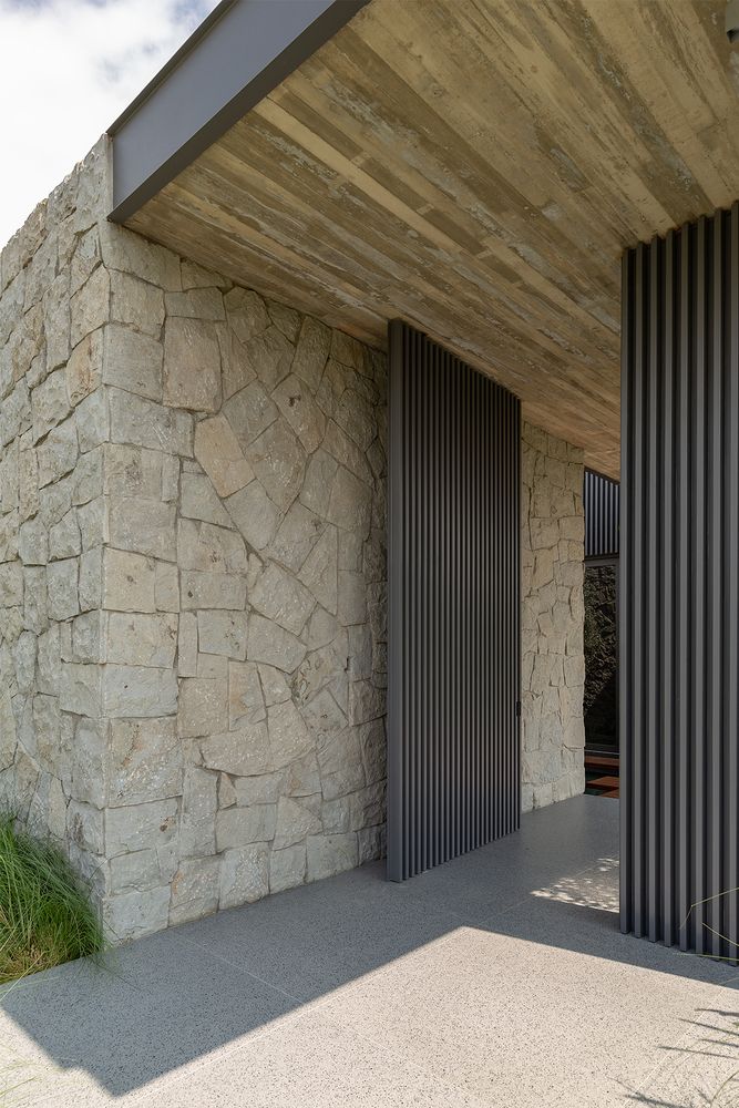 an exterior view of a house with stone walls and metal doors on the outside wall