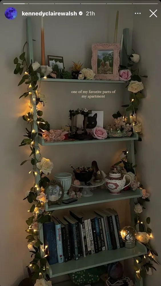 a shelf filled with lots of books next to a wall covered in flowers and greenery