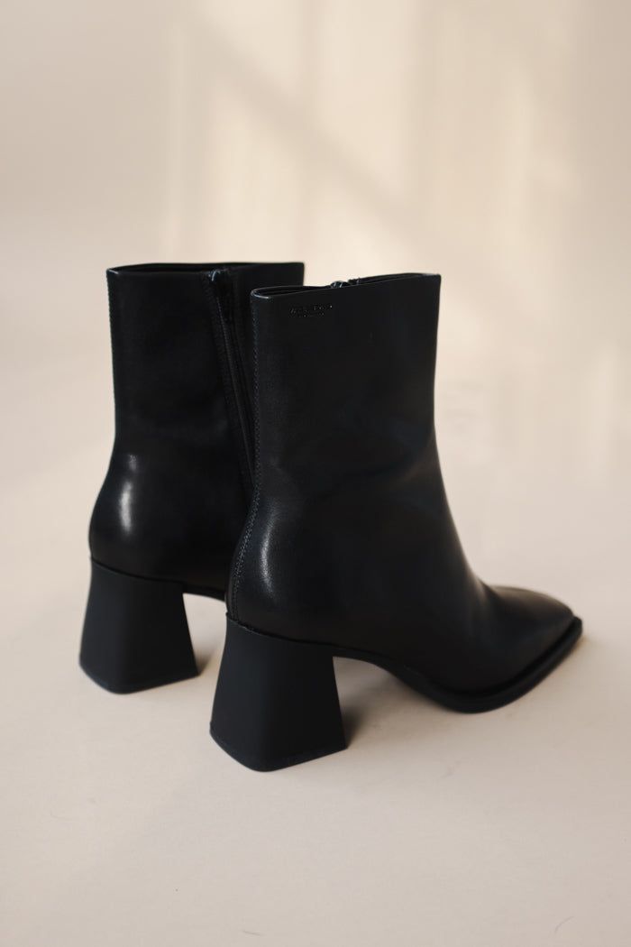 Vagabond Hedda mid-high boots in black have a retro aesthetic to it with its curved block heels and flat square toes. The upper is crafted from smooth black leather featuring a squared-toe finish and angled high heels. Zipped inside for easy wear and removal. Heel height: 70 mm, shaft height: 209 mm, shaft width: 247 mm. Leather upper. Tencel lining. Goat leather inner sole. TPU outsole. The insole is made from chrome-free tanned leather. 5002-001-20 PIPE AND ROW Vagabond Hedda, Mid High Boots, Short Black Boots, Black Pipe, Business Casual Outfits For Work, Black Heel Boots, Goat Leather, Retro Aesthetic, Business Casual Outfits