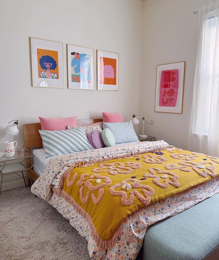 a bed sitting in a bedroom next to two framed pictures on the wall above it