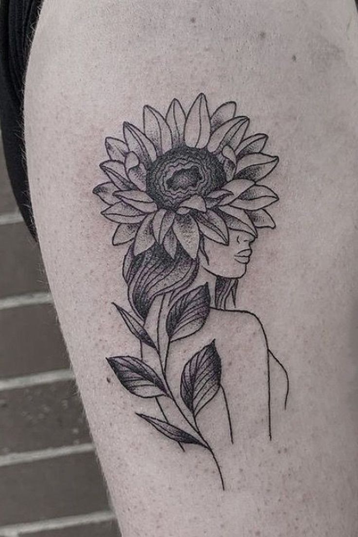 a woman with a sunflower tattoo on her thigh is shown in black and white