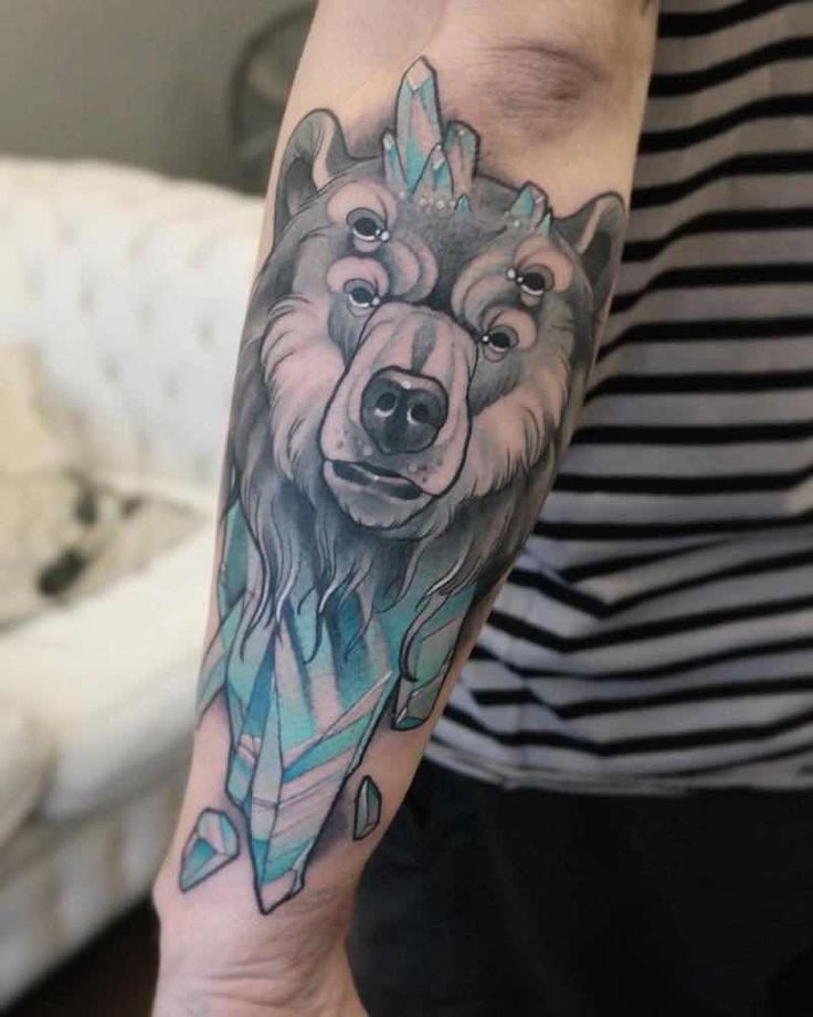 a person with a tattoo on their arm that has a wolf and arrow on it