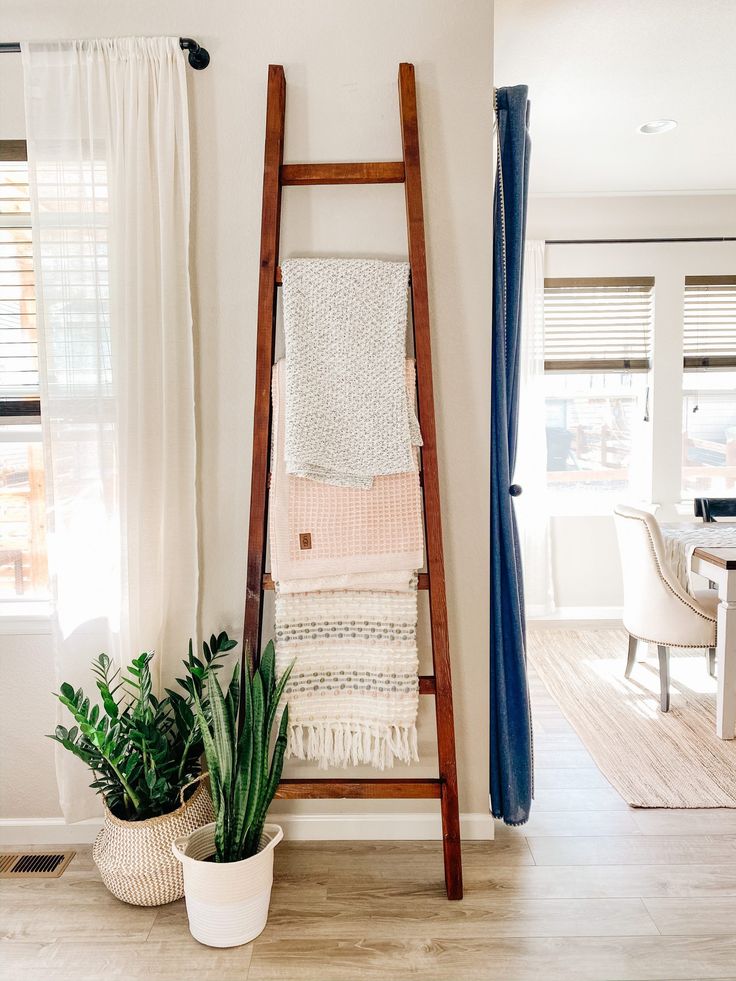 a ladder leaning up against a wall next to a potted plant