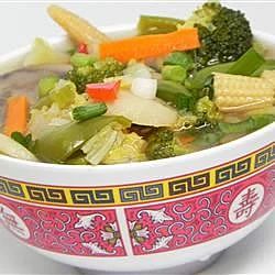 a bowl filled with soup and vegetables on top of a table