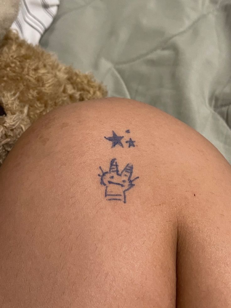 there is a tattoo on the back of a person's stomach that has stars and a crown on it