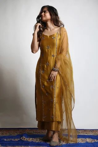 Burnt gold straight kurta in dupion silk base with zari and sequins hand embroidered tiered motifs. Comes with wide legged pant and an organza dupatta.
Component: 3
Pattern: Embroidered
Type Of Work: Zari, Sequins
Neckline: Round
Sleeve Type: Sleeveless
Fabric: Kurta and Pant : Dupion Silk, Dupatta : Organza 
Color: Gold
Other Details: 
Closure : Pant : Fixed belt at front and elastic at back, Opening on the side with a Zip and Hook
Occasion: Mehendi and Haldi, Sangeet - Aza Fashions Lehanga Idea, Salwars Design, Haldi Dresses, Silk Kurtis, Kurtis Design, Stylish Kurtis, Ethnic Dresses, Clothing Wishlist, Long Kurta