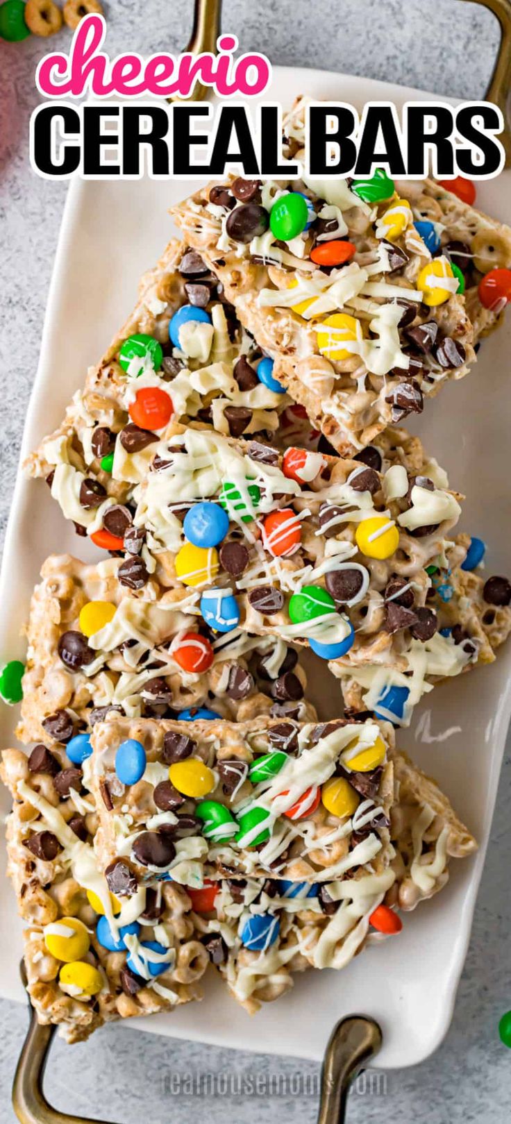 some kind of cereal bar on a white plate with candy and m & m in the background