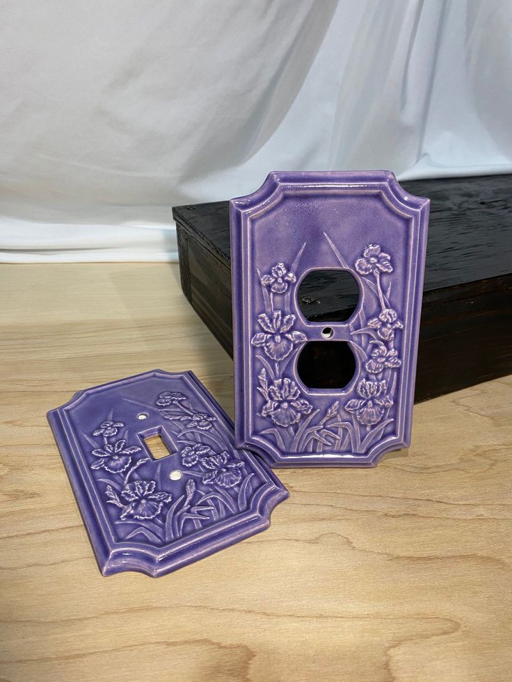 two purple decorative items sitting on top of a wooden table