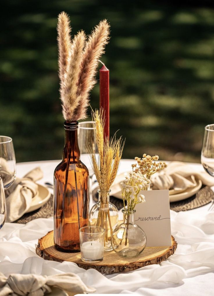 the table is set with wine bottles and place settings