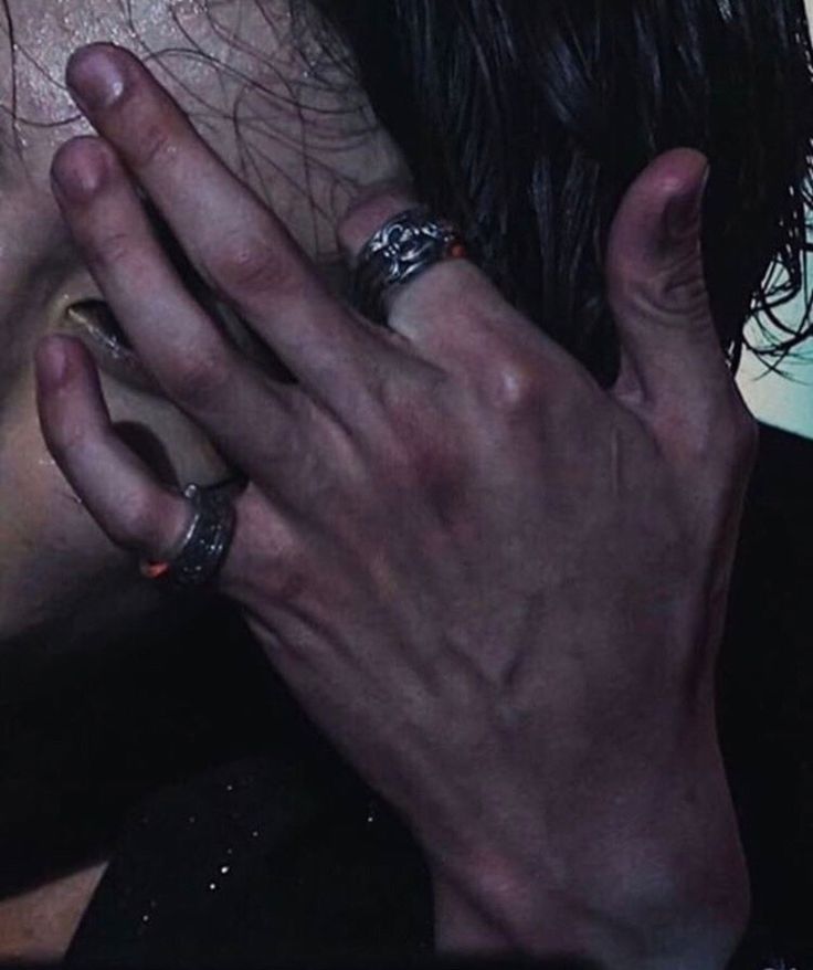 a close up of a person holding their hands to his face with both hands together