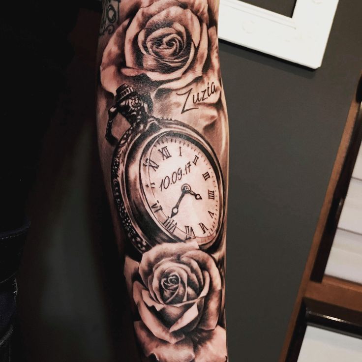 an arm tattoo with roses and a pocket watch on the left side of the arm