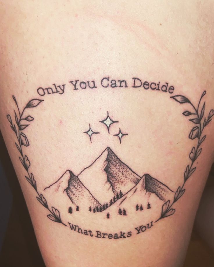 a tattoo with the words only you can decide what breaks you up and mountains behind it