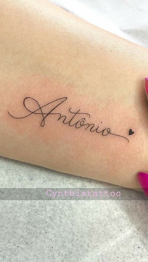 a woman's arm with the word antonio written on it and a pink flower