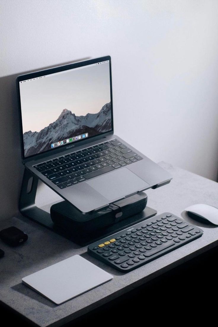 an open laptop computer sitting on top of a desk next to a keyboard and mouse