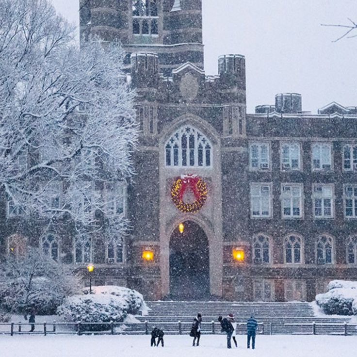 three people are standing in front of a building on a snowy day