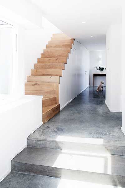 the stairs in this house are made of concrete and wood, while the floor is painted white