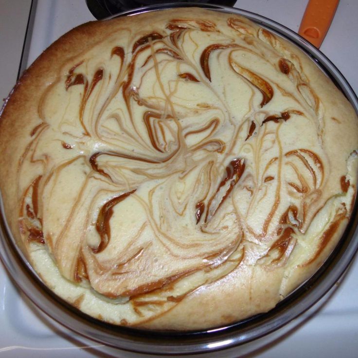 a cake sitting on top of a stove covered in frosting and caramel swirls