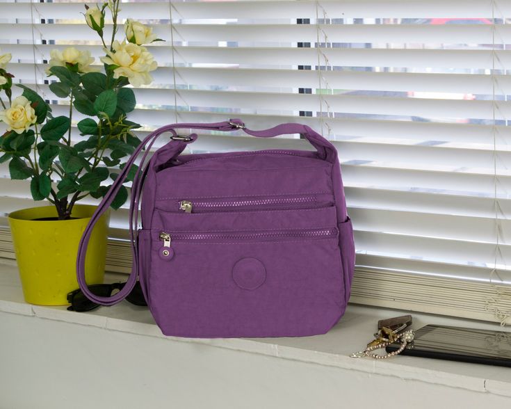 -Multi-pocket Nylon Handbag  Waterproof Shoulder Bag  - lightweight Crossbody Bag - Casual  Work   Travel City Bag Purple -Showerproof material. -Very lightweight, ideal for people who can't carry much weight. -Outer Material: Synthetic -Closure: Zipper -Structure: 1 main compartment with 1 zipped inside pocket, 1 zipped pocket at the back, 3 zipped    pockets in front and 2 bottle slots at the sides. -Size: 26(L)x22(H)x12(W)cm. Fits an iPad. Strap length: 75-140cm. Can be used as a crossbody or shoulder     bag by adjusting the strap. -Useful for: everyday use, travel, holidays, trips. Ideal as a gift for birthdays, Christmas or Mother's Day. Boho Tote Bag, Cotton Handbag, Boho Tote, Nylon Shoulder Bag, Handbag Essentials, Nylon Handbag, City Bag, Purple Bags, Gorgeous Bags