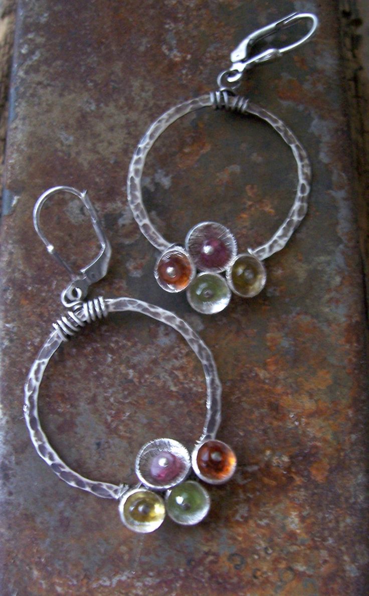 These super sweet colorful sterling silver gemstone hoop earrings from the Tiny Bubbles Collection feature multi-colored gemstones. They are hand textured sterling silver hoops are dotted with sterling silver cups and filled with peridot, carnelian , citrine and pink tourmaline. The hoops are 1' in diameter and are hung from oxidized sterling silver leverbacks. They come in a gift box perrfect for gift giving or safe keeping. Fusion Style Sterling Silver Hoop Earrings As Gift, Silver Circle Gemstone Jewelry, Unique Multicolor Birthstone Jewelry, Nickel Free Multicolor Hoop Jewelry, Unique Multicolor Small Hoop Jewelry, Silver Fusion Hoop Earrings As Gift, Unique Gemstone Hoop Jewelry, Silver Fusion Hoop Earrings For Gift, Fusion Style Silver Hoop Earrings As Gift