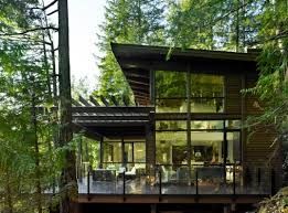 a house in the woods with lots of windows on it's roof and deck