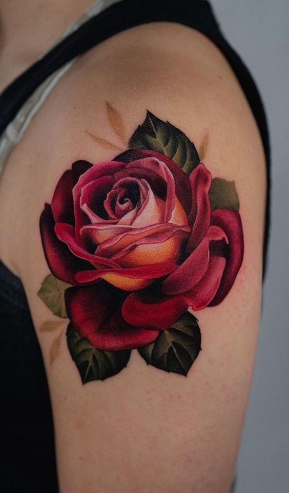 a woman's shoulder with a rose tattoo on it