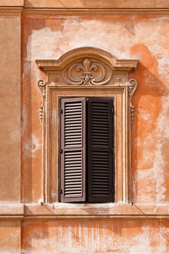 an old window with black shutters on the side of a building in venice, italy