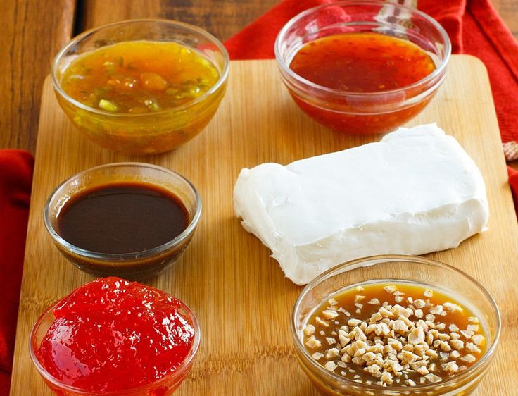 the ingredients to make an appetizer are displayed on a cutting board, including sauces and condiments