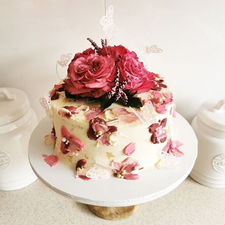 a white cake with pink and red flowers on top