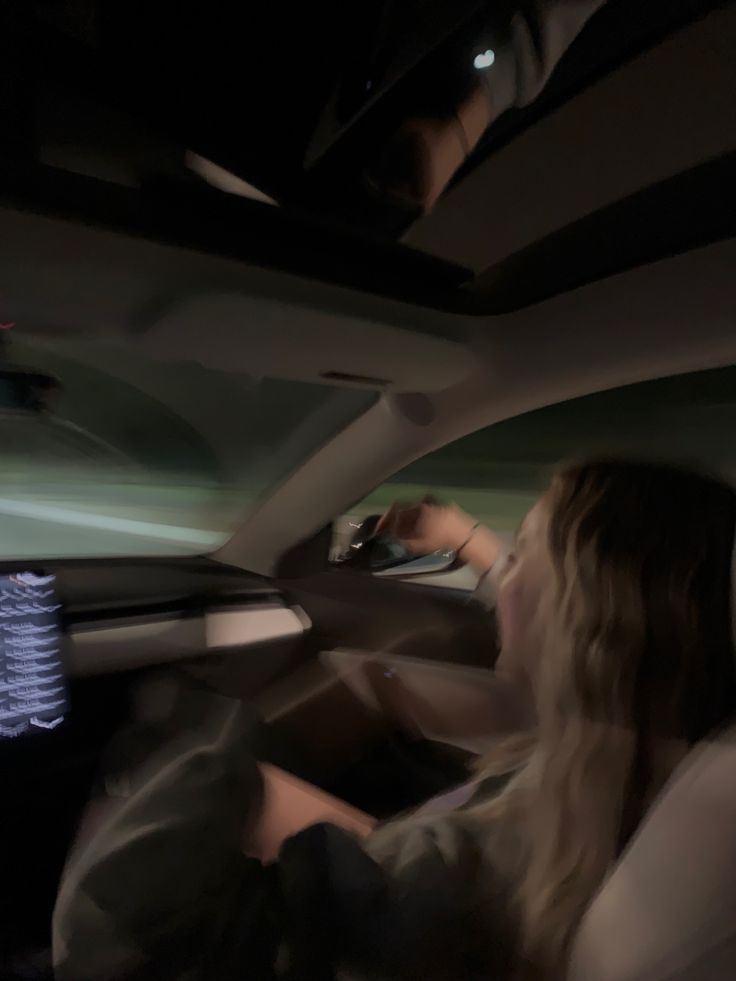 a woman sitting in the driver's seat of a car