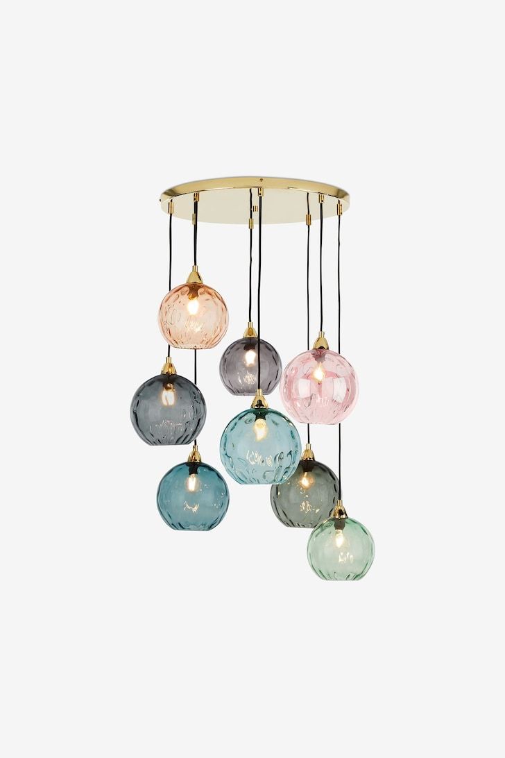 five glass globes hanging from a ceiling fixture with lights on each side and one light in the middle