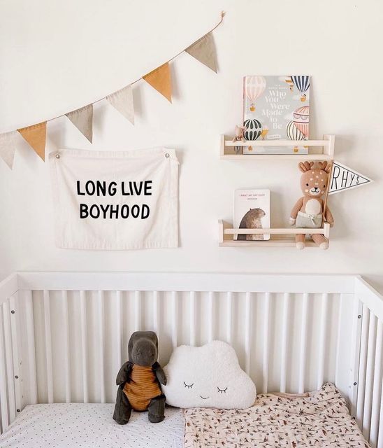 a baby crib with a teddy bear and stuffed animal on it's side