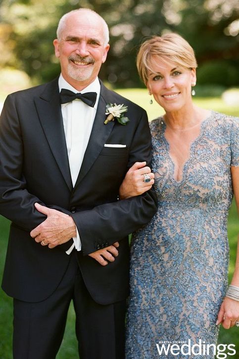 an older man in a tuxedo poses with his wife